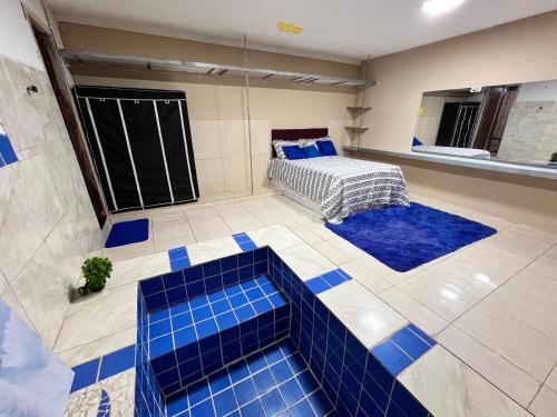 a room with blue tiles on the floor and a bed at Chacará Village do Rio Ouro in Conde