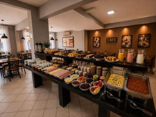 a buffet line with many different types of food at iG Hotel - Canasvieiras in Florianópolis