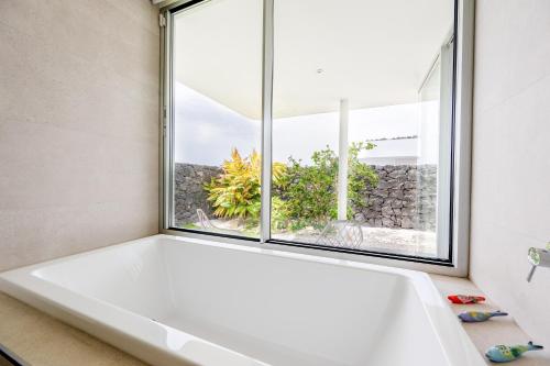 a bath tub in a bathroom with a window at Villa Veiga with heated pool in Callao Salvaje