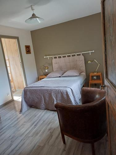 a bedroom with a bed and a chair at La maison de l'écluse in Trèbes