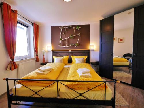 a bedroom with two beds with yellow sheets at Fewo Penthaus-Blick in Willingen