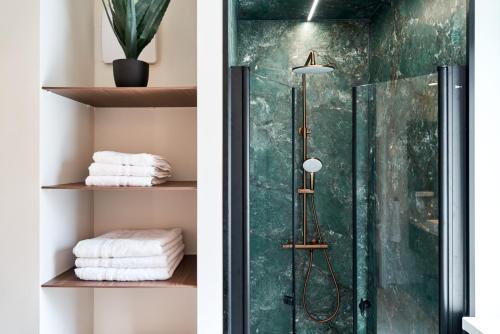 two images of a bathroom with a shower and towels at Stadtmauerloft - Premium Apartment in Eisenstadt