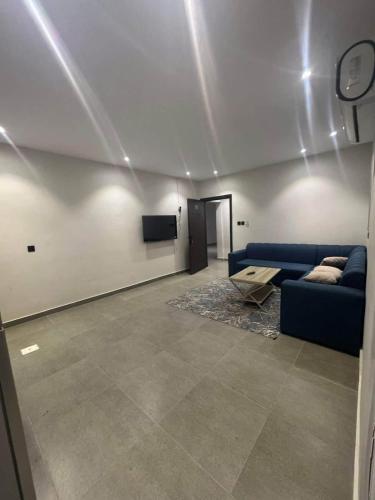 a living room with a blue couch and a tv at المارنز in Baghdād