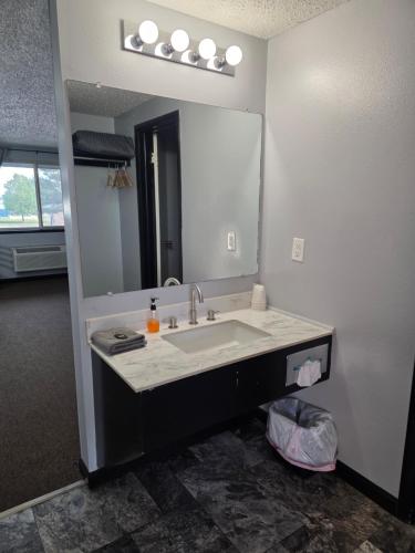 a bathroom with a sink and a large mirror at Fort Union Inn in Colstrip