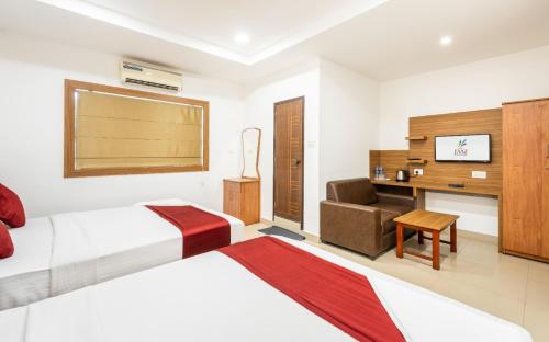 a hotel room with two beds and a desk at Hotel Faaz international in Thottada