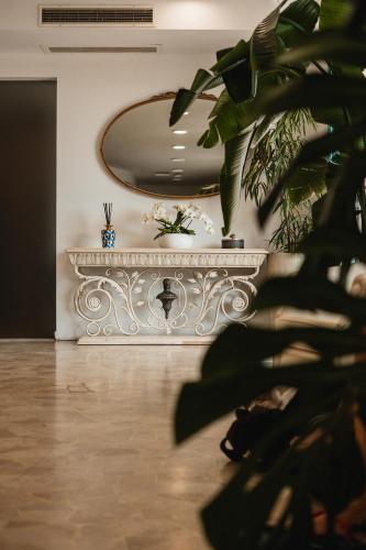 a white room with a table and a plant at Hotel Delaville Frontemare in Lido di Jesolo