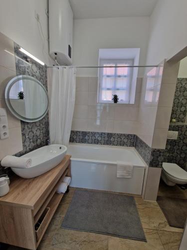 a bathroom with a tub and a toilet and a sink at Happyzem in Sátoraljaújhely