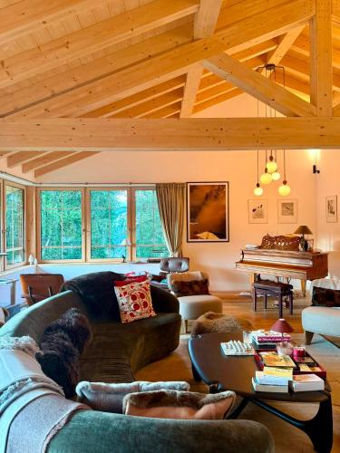 a living room with a couch and a piano at La Tzoumaz Lodge in La Tzoumaz