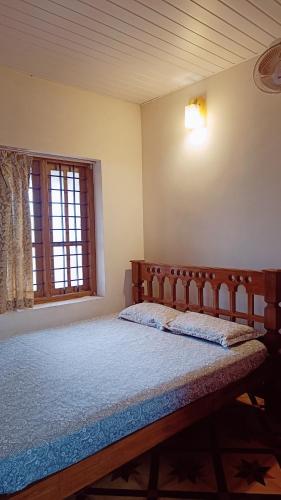 a bedroom with a bed in a room with a window at Verdant Vagamon Cottage in Vagamon