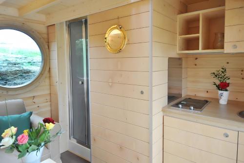 a tiny house with a kitchen and a window at Cabane Le Carré D'étoiles in Voussac