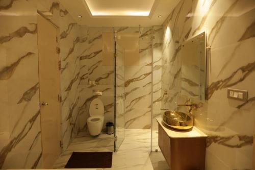 a bathroom with a toilet and a glass shower at The Woods by CASA D' GAVA in Lucknow