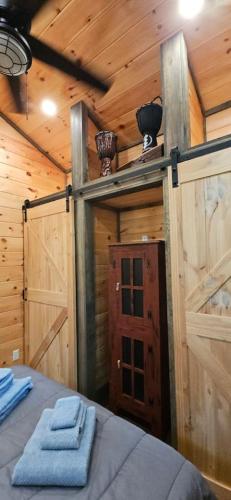 a room with a bed in a cabin with wooden walls at Amazing Mountain View Tiny House in Hayesville