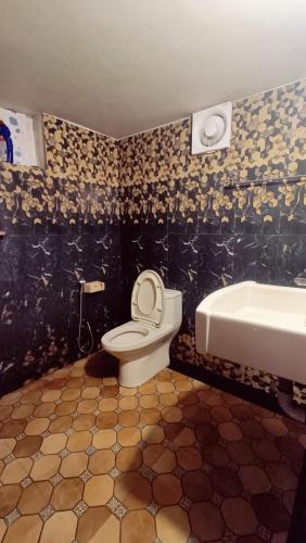 a bathroom with a toilet and a sink at Verdant Vagamon Cottage in Vagamon