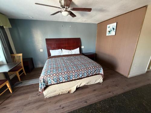 a bedroom with a bed and a ceiling fan at Cinderella Motel in Wasco