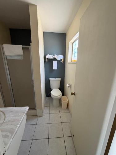 a bathroom with a toilet and a sink at Cinderella Motel in Wasco