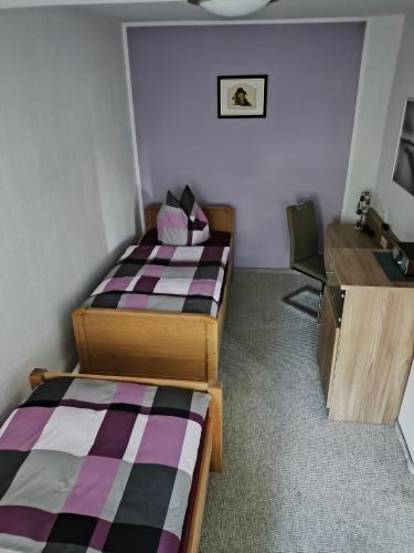 a room with two beds and a desk and a sink at Ferienwohnung Luka in Kaulsdorf