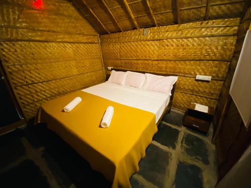 a bed in a small room with two phones on it at Sunshine café Hampi in Hampi
