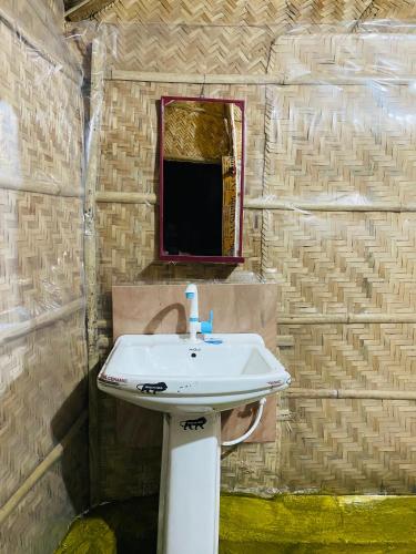 a bathroom with a white sink and a mirror at Sunshine café Hampi in Hampi