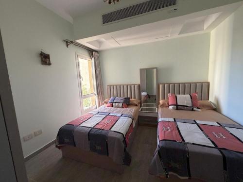 a bedroom with two beds in a room at North Coast sedra resort Villa, قرية سيدرا الساحل الشمالي in Alexandria