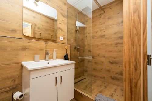 a bathroom with a white sink and a shower at Luxapartment Jacuzzi with Breakfast option in Košice