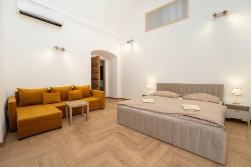 a bedroom with a large bed and a couch at Luxapartment Jacuzzi with Breakfast option in Košice