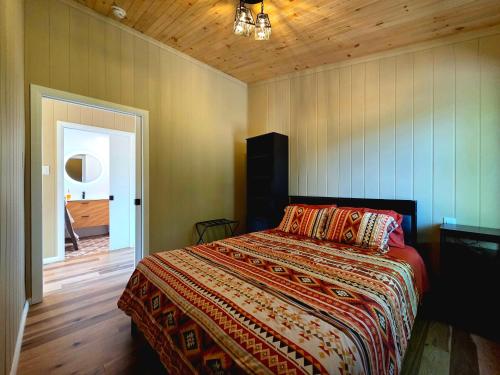a bedroom with a bed and a wooden ceiling at Camping Abenaki Aventure - Les Chalets in Pierreville