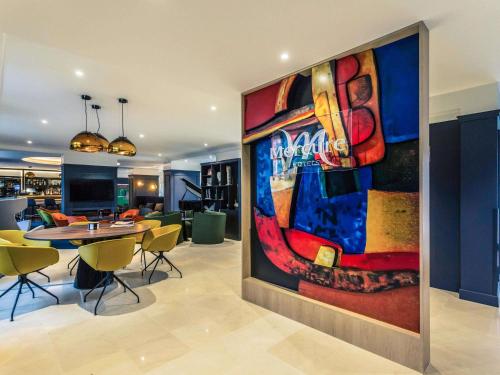 a large painting on the wall of a living room at Hotel De Bourbon Grand Hotel Mercure Bourges in Bourges