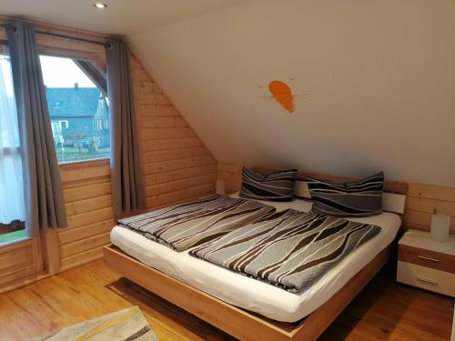 a bed in a room with a window at Blockbohlenhaus-Steiner-Lodge in Steinen