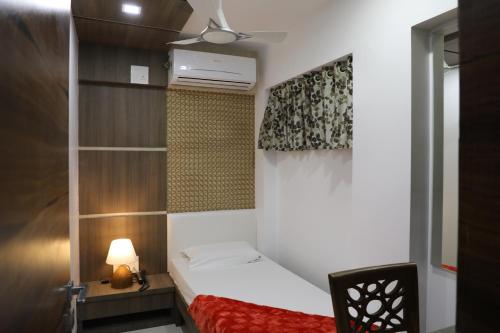 a small bedroom with a bed and a window at Hotel Fantacee in Navi Mumbai