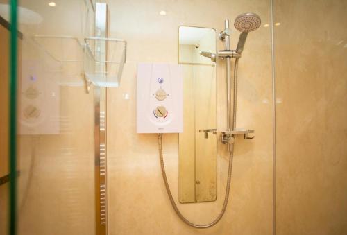 a shower in a bathroom with a glass door at Ger Y Llanw Aberaeron in Aberaeron