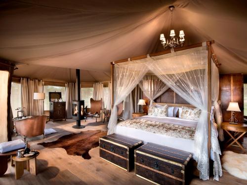 sypialnia z łóżkiem z baldachimem w namiocie w obiekcie One Nature Nyaruswiga Serengeti w mieście Banagi
