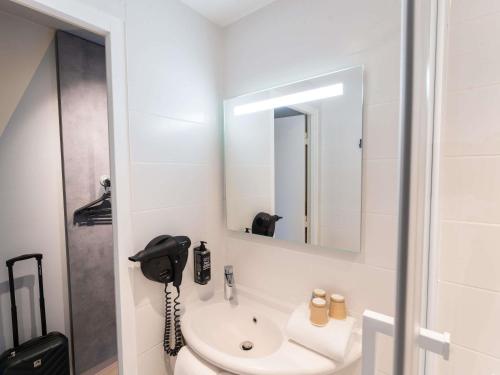 a bathroom with a sink and a mirror at Hotel Ibis Budget Rennes Cesson in Cesson-Sévigné