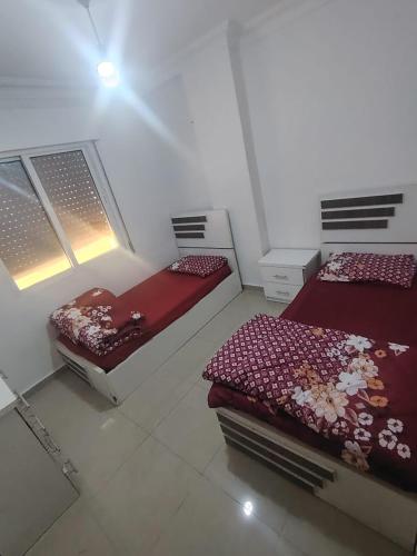 ein Schlafzimmer mit zwei Betten und zwei Fenstern in der Unterkunft Remas23 in Irbid