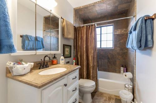a bathroom with a sink and a toilet and a shower at Fly Away Home in West Jordan