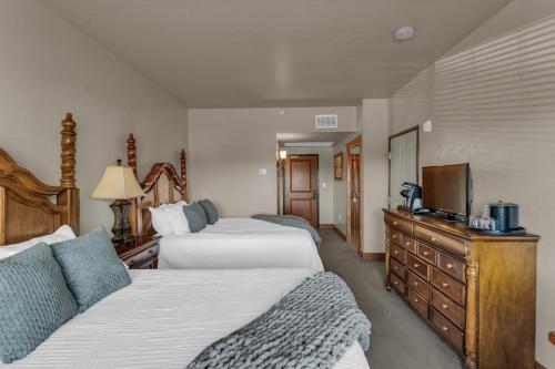 a hotel room with two beds and a flat screen tv at Zermatt Mountain Lodge Studio in Midway