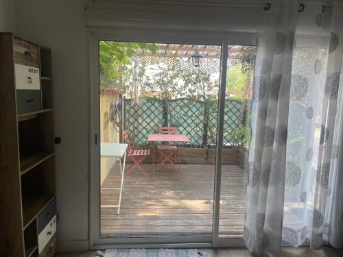 a sliding glass door leading to a patio with a table at Studio Oustaou à Château Gombert in Marseille