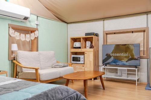 a room with a bed and a tv and a chair at Pocheon Terrace 527 Campground in Pocheon