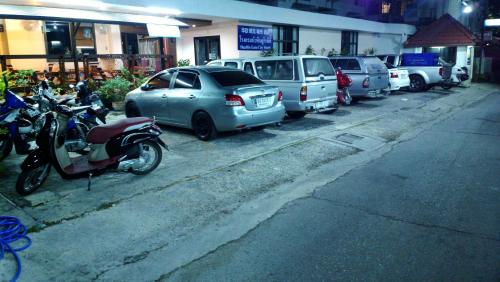 a row of cars and motorcycles parked on a street at Hua Hin Euro City Hotel in Hua Hin