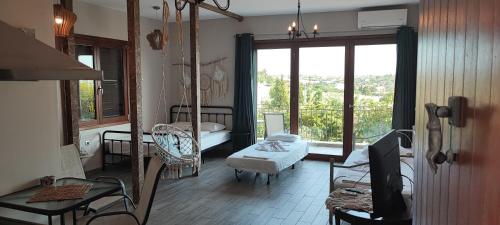 a living room with a large window and a room with a chair at Stone house with seaview in Nea Potidaea