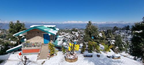 a building on top of a snow covered mountain at Dharohar Retreat, Mukteshwar in Mukteshwar