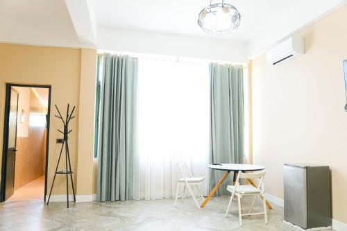 a living room with a table and chairs and a window at Gazulli Guesthouse in Lezhë