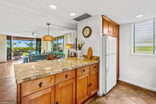 a kitchen with a large counter and a dining room at Maui Eldorado Condo J123 in Kaanapali