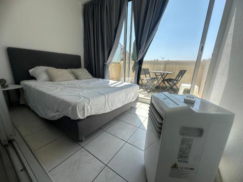 a bedroom with a bed and a balcony with a table at CaroCarnon in La Celle-sous-Gouzon