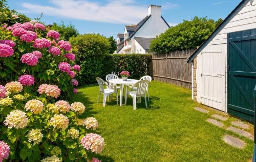 a table and chairs in a yard with flowers at Maison Piriac in Piriac-sur-Mer