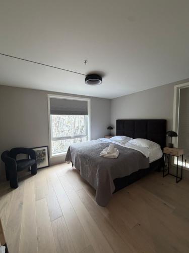 a bedroom with a bed and a chair and a window at NORDIQ by the Fjord in Spro
