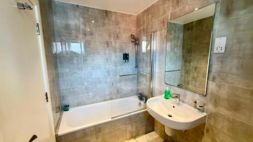 a bathroom with a sink and a shower and a tub at Hotel Blackpool in Blackpool