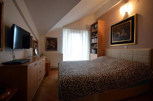 a bedroom with a bed and a flat screen tv at T&A Apartments in Ohrid