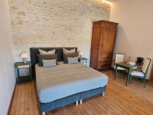 a bedroom with a bed and a table and a chair at Le Domaine de Champerou - Chambres d'hôtes in Cabariot