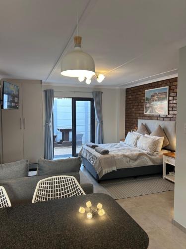 a bedroom with a bed and a living room at Whale's Cove in Amanzimtoti