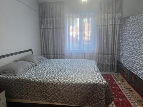a bedroom with a large bed with a window at Guest House Aska Ethno in Kochkorka